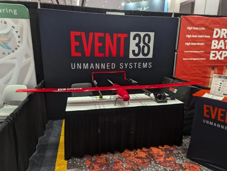 A photo of a red fixed wing drone on display at an expo