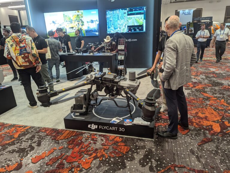 A photo of a large drone on display at an expo with people standing near it