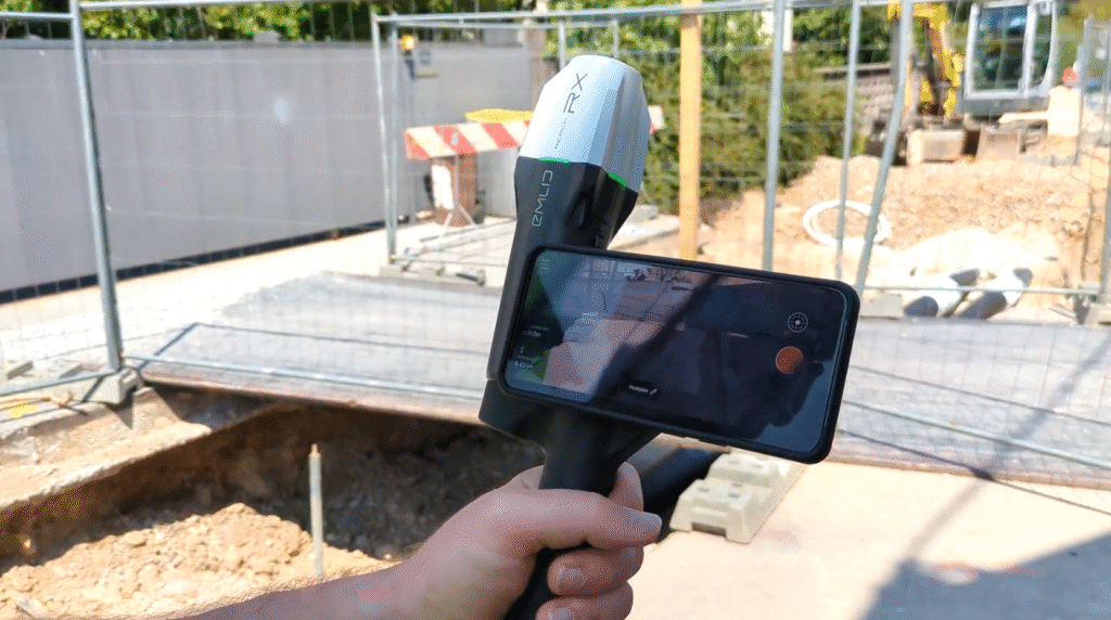 Surveyor onsite holding a smartphone with rtk device attached to it ready to record